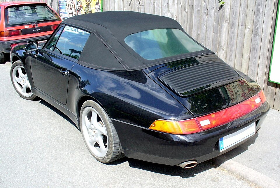 Dark blue Porsche 993 Cabriolet viewed from behind with its soft top closed
